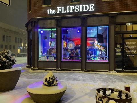 The Flipside exterior at night, sign lit, snow on the ground